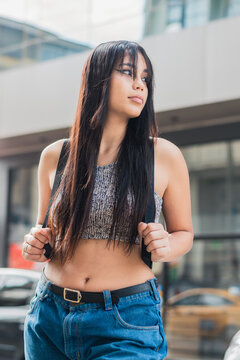 beautiful latina girl with brown skin waiting for public transportation in the city of Pereira-Colombia. young university student waiting to go to school. concept of education.
