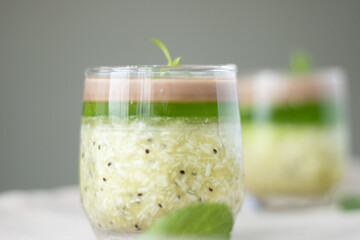 Kiwi yogurt parfait in glass jars on concrete background. Selective focus, copy space.