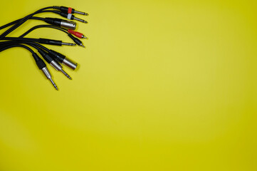 Layout of various audio cables on a yellow background.Copy space
