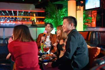 Group of friends having fun and celebration at karaoke club