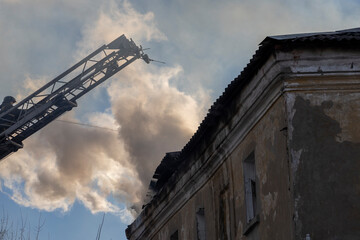 Firefighter pours water on fire. Rescue services during work. Extinguishing fire from hydrant....