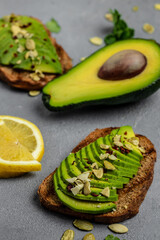 Healthy avocado toasts with rye bread, sliced avocado for breakfast or lunch. Vegetarian food. Vegan menu. Food recipe. vertical image. top view. place for text