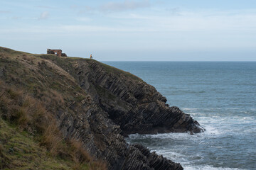 chica en acantilado con el horizonte del mar
