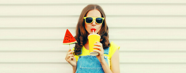 Summer portrait of young woman drinking fresh juice with ice cream shaped slice of watermelon or lollipop on stick on white background, blank copy space for advertising text