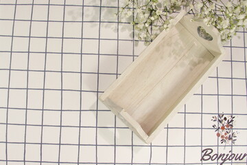 White wooden tray on square cloth and flowers