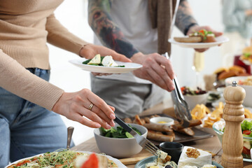People near buffet table with food indoors, closeup. Brunch setting