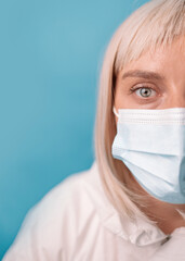 Doctor in protective suit medical mask gloves over bright blue color background