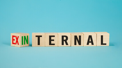 External and internal on wooden cubes, dice or blocks showing the words external and internal on blue background.Business concept.