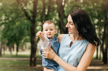 Happy mother and baby looking into the camera in summer day