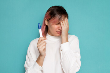 Frustrated young woman with pregnancy test