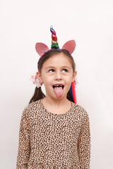 Funny funny little girl teases showing tongue standing on a white background