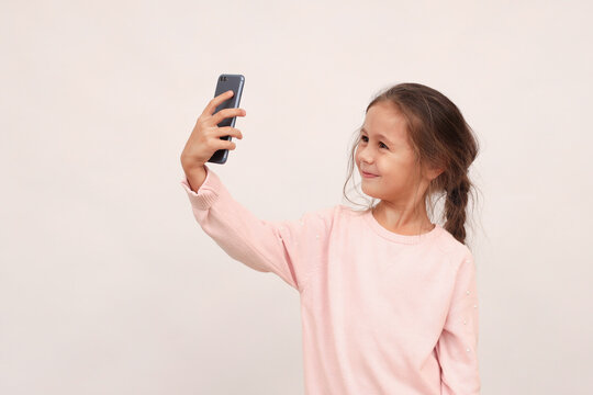 Little girl taking a selfie photo with a smart phone