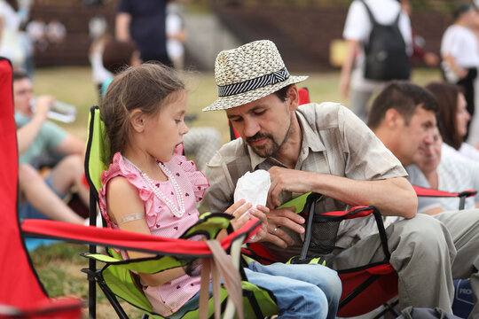 Yelabuga, Russia - July 18, 2021:  Dad and daughter are sitting in camping chairs at an open-air music festival