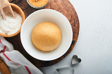 Baking ingredients and kitchen utensils on a white background top view. Preparing heart sugar cookies. Baking background. Flour, eggs, sugar, spices, and a whisk on the kitchen table. Flat lay.