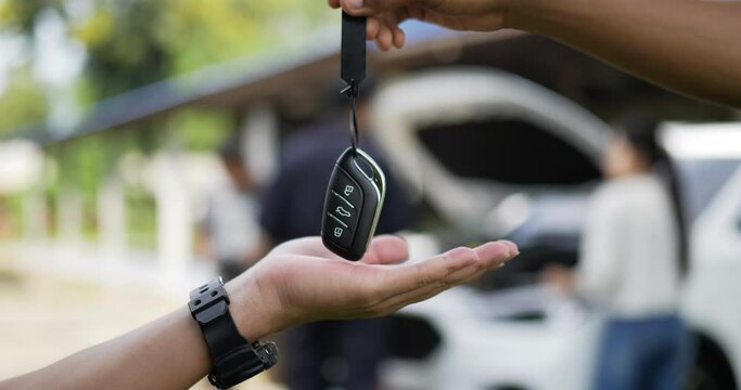 Close up hand of Seller man sends the keys to the new auto to the new owner. Selling and renting cars concept.