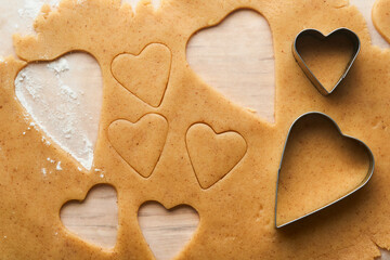 Baking ingredients and kitchen utensils on a white background top view. Preparing heart sugar cookies. Baking background. Flour, eggs, sugar, spices, and a whisk on the kitchen table. Flat lay.