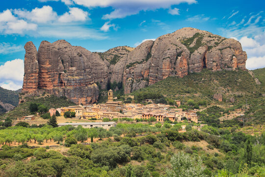 View of the town of Ag&uuml;ero (Huesca, Spain) at the foot of the rock formations "Mallos de Ag&uuml;ero"