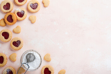 Traditional Linzer cookie with strawberry jam and powder sugar on pink beautiful background. Top view. Homemade Austrian sweet dessert food on Valentines Day. Holiday snack concept.