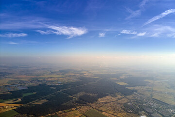 Obraz premium Aerial view of farm fields and distant scattered houses in rural area