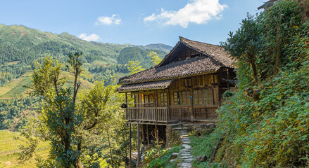 Traditional wooden farm house amidst the Longsheng rice terraces in summer, Guangxi Province, China
