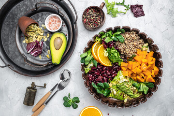 Obraz na płótnie Canvas Ingredients for making Quinoa salad on gray background. Vegetable salad in bowl, avocado, sweet potato, beans, herbs. Clean healthy detox eating. Vegan vegetarian food. Making healthy salad. top view