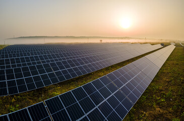 Aerial view of large sustainable electrical power plant with rows of solar photovoltaic panels for...