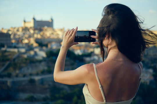 Woman tourist photographing famous landmarks of Toledo. Spain