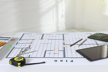 Construction drawing, tablet and roulette on table in office