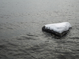 Rock in the sea covered in beautiful ice. Beautiful and tranquil wintery background.