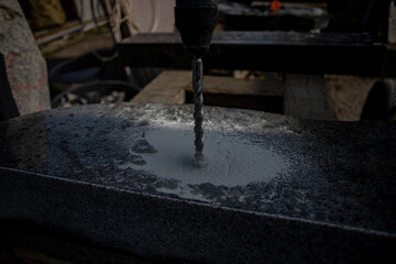 drilling hole in granite surface, dirt and dust