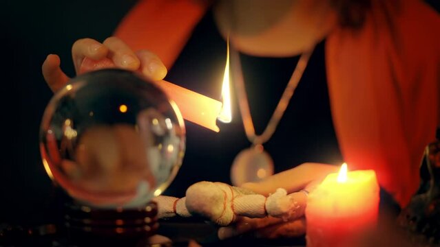 Soothsayer conjuring voodoo doll, crystal ball, psychic powers, black magic