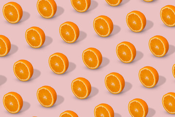 Fresh sliced orange on pastel pink background. Fruit pattern, creative summer concept.