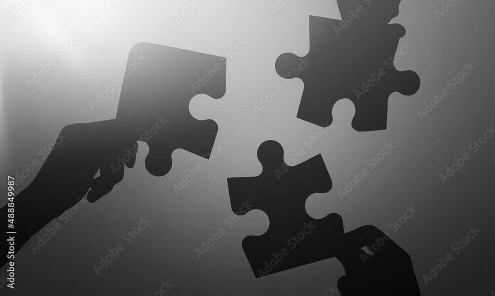 Wall mural hands of businessman to connect couple puzzle piece with background.