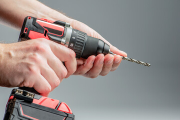 The man's hands install the drill into the drill, the hands take the drill and install it into the...