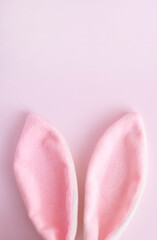 Easter  vertical greeting card  .Pink  eggs and bunny ears  on pink  pastel background with  copy spase  . Easter minimal concept. Flat lay. advertising concept .