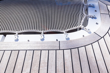 Fototapeta premium Part of a stretched white net with ropes threaded into loops on the catamaran hull.