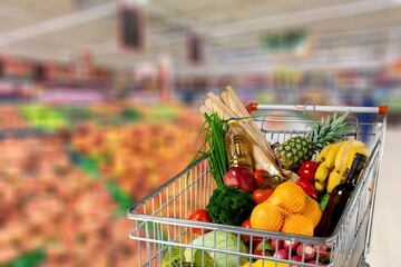 A shopping cart full of food in a supermarket