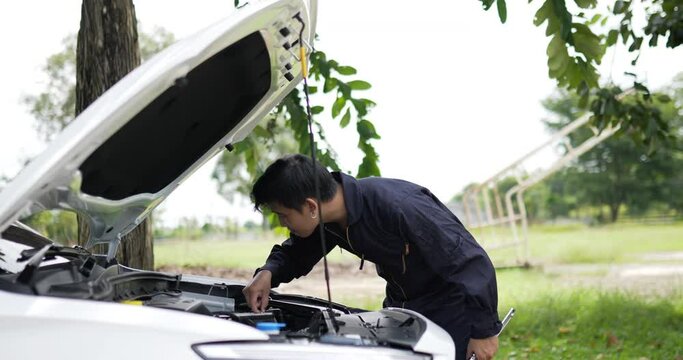 Asian Man mechanic inspection shine a torch car engine checking bug in engine. Service maintenance insurance with car engine. Car service concept.