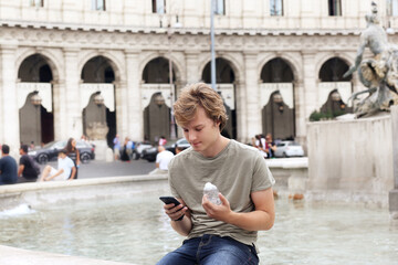 Using smart phone.Teenage boy typing text message.Tourist looking at map