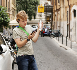 Teenage boy typing text message,Using smart phone,young man on a city street