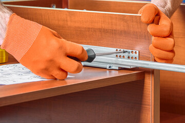 The worker fastens the guide with the closer for the drawer.