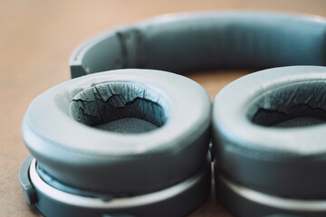 gray headphones and deformed ear cushions with cuts and cracks