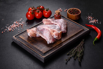 Chicken wings lie on a wooden board on a black background