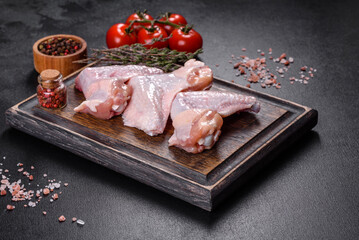 Chicken wings lie on a wooden board on a black background