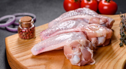 Chicken wings lie on a wooden board on a black background