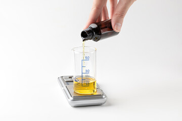 Equipmen with glass volumetric flask with measurement on scales on white