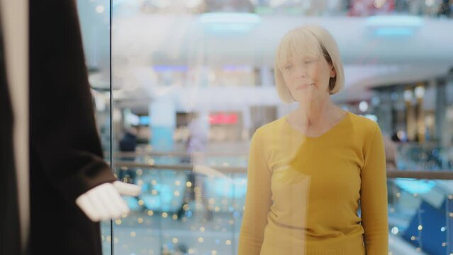 Mature Middle Aged Caucasian Woman Looking Sadly At Showcase Window Clothing Store In Shopping Mall Upset Frustrated Sad Because Higher Prices Costly Purchase Luxury Too Expensive Not Affordable