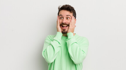 young handsome man feeling happy, excited and surprised