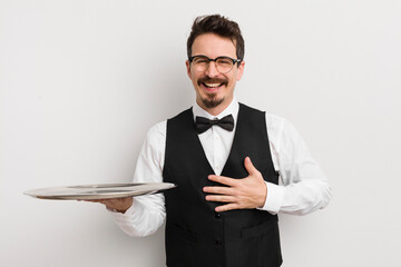 young handsome man laughing out loud at some hilarious joke. waiter and tray concept