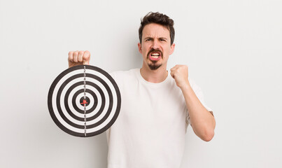 young handsome man shouting aggressively with an angry expression. dart target concept